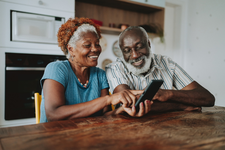 Portrait senior couple using smartphone at home