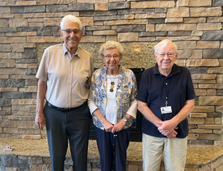 three seniors standing shoulder to shoulder and posing for a photo