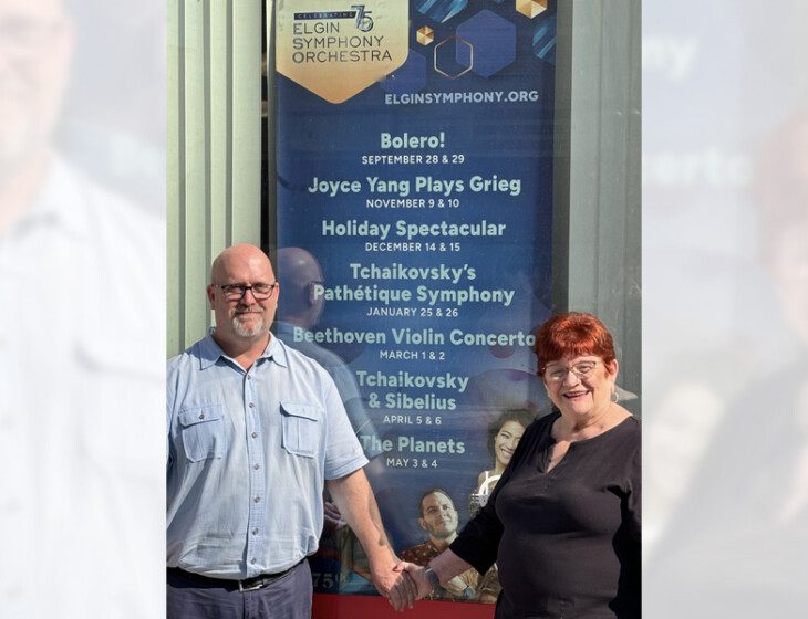 senior couple poses for a photo in front of an award