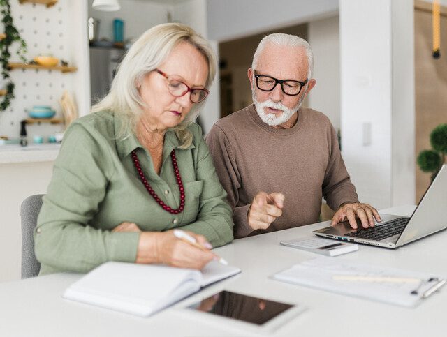 Senior couple using laptop while planning their home budget,