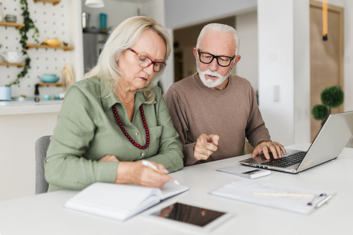 Senior couple using laptop while planning their home budget,